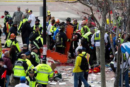 FIRST RESPONDERS TEND to the wounded where two explosions occurred along the final stretch of the Boston Marathon on Boylston Street in Boston on Monday. Two powerful explosions rocked the finish line area of the Boston Marathon near Copley Square and police said many people were injured. / BLOOMBERG PHOTO/KELVIN MA FIRST RESPONDERS TEND to the wounded where two explosions occurred along the final stretch of the Boston Marathon on Boylston Street in Boston on Monday. Two powerful explosions rocked the finish line area of the Boston Marathon near Copley Square and police said many people were injured. / BLOOMBERG PHOTO/KELVIN MA