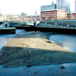 TURBULENT WATERS: A 2007 photo showing the buildup of material and low water level in a downtown waterway that can make navigation by WaterFire boats impossible. / COURTESY WATERFIRE