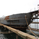 SHIPPING OUT: The hull of the SSV Oliver Hazard Perry at the Senesco Marine shipyard. In mid-June the vessel will be towed to Newport, where it will be hauled from the water so the hull can be painted and the masts stepped. / COURTESY OHPRI/ROD SMITH