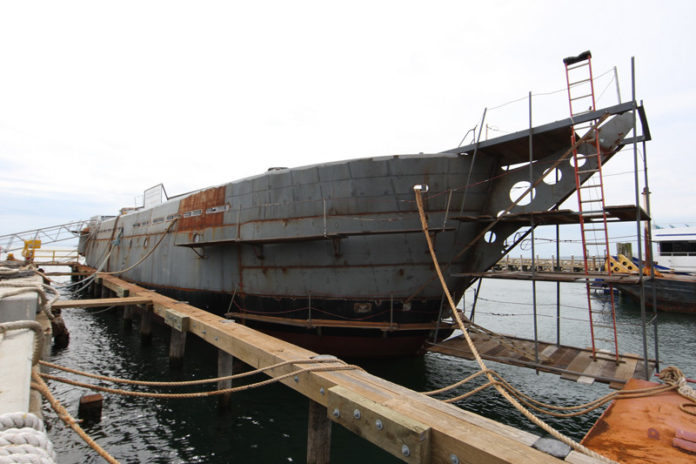 SHIPPING OUT: The hull of the SSV Oliver Hazard Perry at the Senesco Marine shipyard. In mid-June the vessel will be towed to Newport, where it will be hauled from the water so the hull can be painted and the masts stepped. / COURTESY OHPRI/ROD SMITH