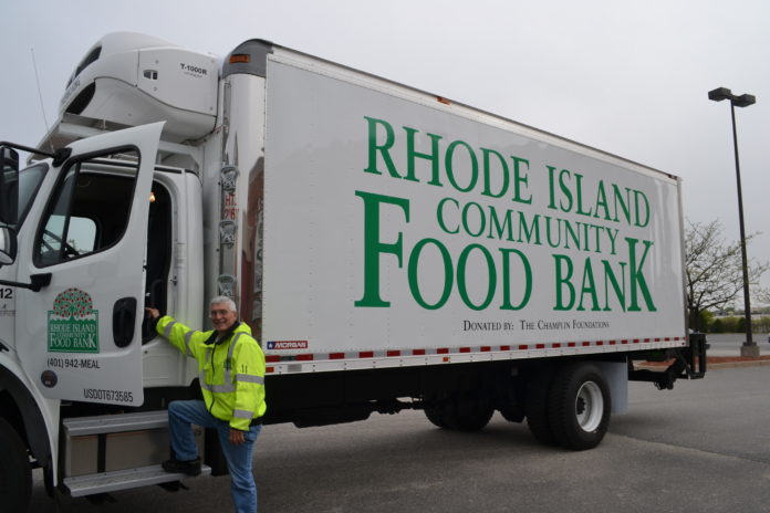 A DRIVE STANDS with a new 22-foot refrigerated truck the Rhode Island Community Food Bank recently added to its fleet thanks to a $120,293 grant from the Champlin Foundations. / COURTESY THE RHODE ISLAND COMMUNITY FOOD BANK