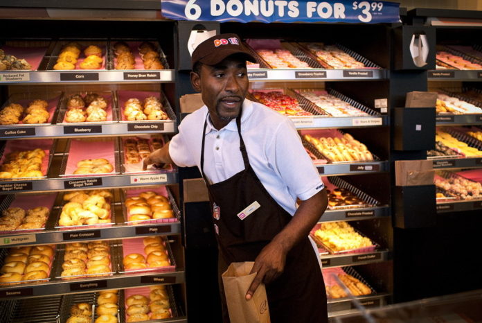 DUNKIN' DONUTS is rolling out new store designs to combat its sugar-caffeine fix pit stop reputation and get customers to stick around the outlets for a long time, a la Starbucks. / BLOOMBERG NEWS FILE PHOTO/EMILE WAMSTEKER