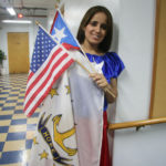 LET IT FLY: Vivian Moreno of the Puerto Rican Cultural Festival and Parade of Rhode Island Inc. shows off the flags she&rsquo;ll be displaying at the national Puerto Rican Day Parade in New York City. / PBN PHOTO/MICHAEL PERSSON