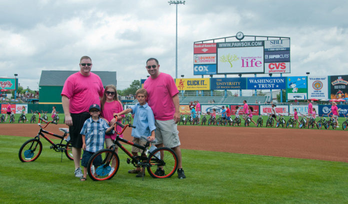 RIDING TO A BETTER FUTURE: Barnum Financial Agency Sales Director Joseph B. Kotula and Special Needs Planner and Financial Services Representative Benjamin Howarth were part of the team that gave out bicycles and helmets to underprivileged children during the Foundation for Life Bikes for Kids event at McCoy Stadium in Pawtucket. / COURTESY BARNUM FINANCIAL GROUP