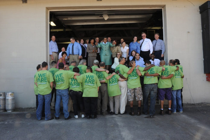 TEAM BANNEKER: At a quarterly corporate meeting, Banneker President and CEO Cheryl W. Snead stands in the center of her team, half of which sport “We are Banneker” T-shirts. / COURTESY BANNEKER INDUSTRIES TEAM BANNEKER: At a quarterly corporate meeting, Banneker President and CEO Cheryl W. Snead stands in the center of her team, half of which sport “We are Banneker” T-shirts. / COURTESY BANNEKER INDUSTRIES