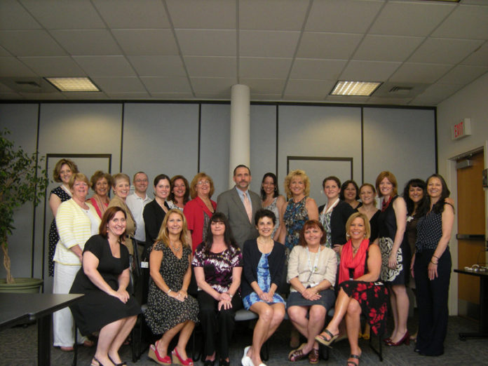 HUDDLING FOR HEALTH: Staff at Healthcentric Advisors gather twice a week to allow all associates to deliver updates, give feedback and share concerns and challenges. / COURTESY HEALTHCENTRIC ADVISORS