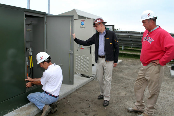 BRIGHT IDEA: From left, Beaumont Solar project manager Scott Milnes, President and CEO Phil Cavallo and master electrician Ed Murphy work on a rooftop project. / PBN PHOTO/KATE WHITNEY LUCEY