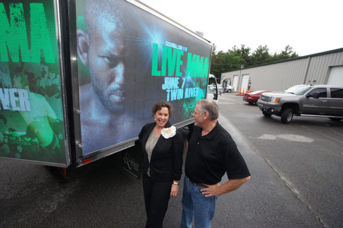 KEEPING IT MOVING: Brian and Jeanne Evans, owners of mobile-outdoor marketing company Promotion With Motion, show off their mobile screen. Building more trucks is the firm’s next move, they say. / PBN PHOTO/BRIAN MCDONALD