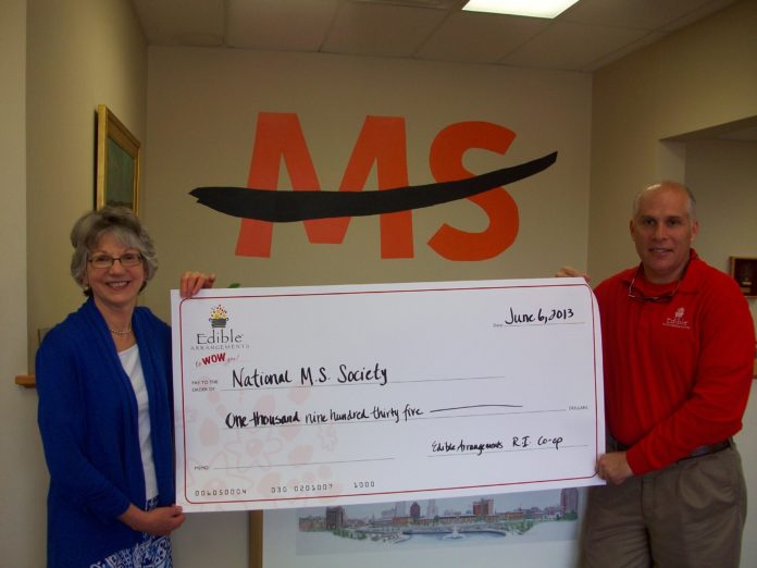 TED KOSTISIN, president of the Edible Arrangements Rhode Island Co-op, presented a $1,935 check to Kathy Mechnig, president of the Rhode Island chapter of the National MS Society to help support MS research and support in Rhode Island.