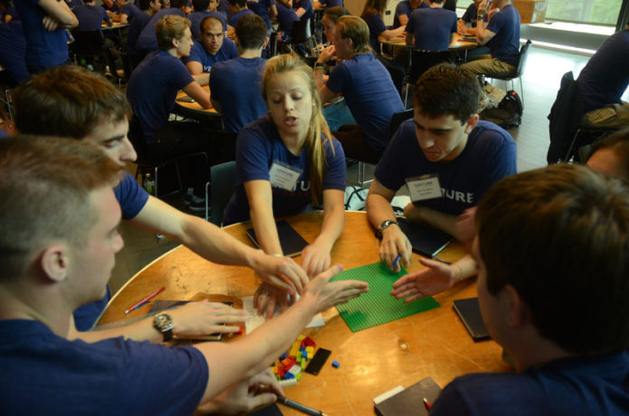 COMING TOGETHER: Venture for America fellows take part in a Lego competition designed to help participants understand team roles and responsibilities, during a training camp at Brown University. / COURTESY EDDIE SHIOMI