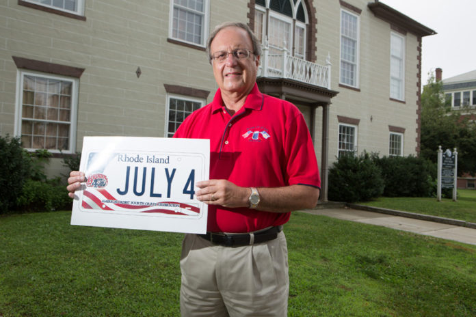 SHOWING PRIDE: Roger Dubord, chairman of the Bristol Fourth of July Parade Committee, shows off a sample charity license plate. The committee is trying to sell its own license plates to help fund the parade, but needs to presell 900 before they can be printed. / PBN PHOTO/RUPERT WHITELEY