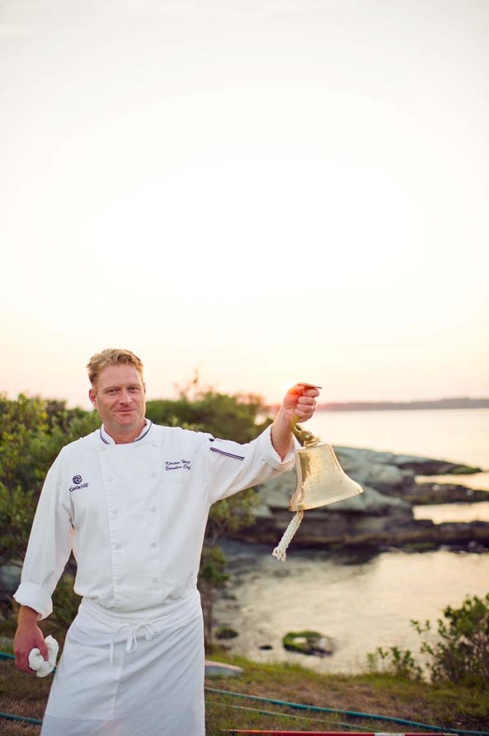 SURF’S UP: Castle Hill Inn Executive Chef Karsten Hart calls the guests to the outdoor table to experience a New England clambake. / COURTESY MICHELLE GARDELLA