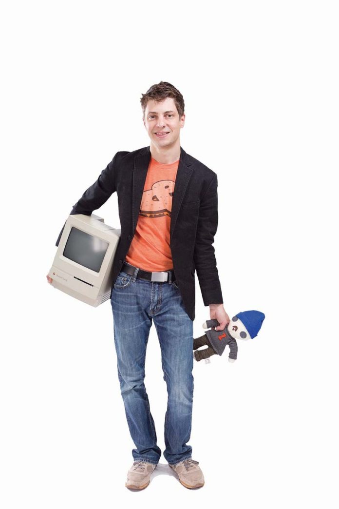 THE PROP: Daniel Chapman loves Web design. Here he holds an old Apple Mac as well as a doll of Web-design pioneer Jeffrey Zeldman.