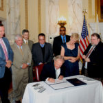 GOV. LINCOLN D. CHAFEE SIGNED legislation expanding the enterprise zone in Pawtucket as officials from Tunstall and the city looked on. / COURTESY R.I. GENERAL ASSEMBLY