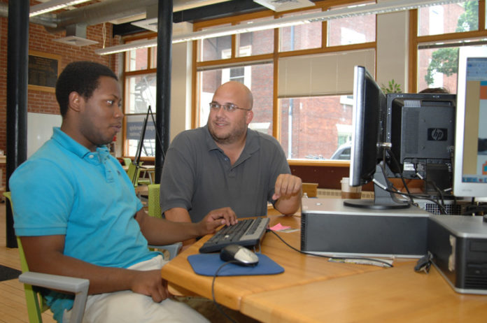 GOOD TO GO: Julius Searight, left, is the 24-year-old founder of Food4Good, a socially conscious mobile soup kitchen. Above, he works with Johnson & Wales University alumni mentor Jeff Ledoux. / PBN PHOTO/BRIAN MCDONALD