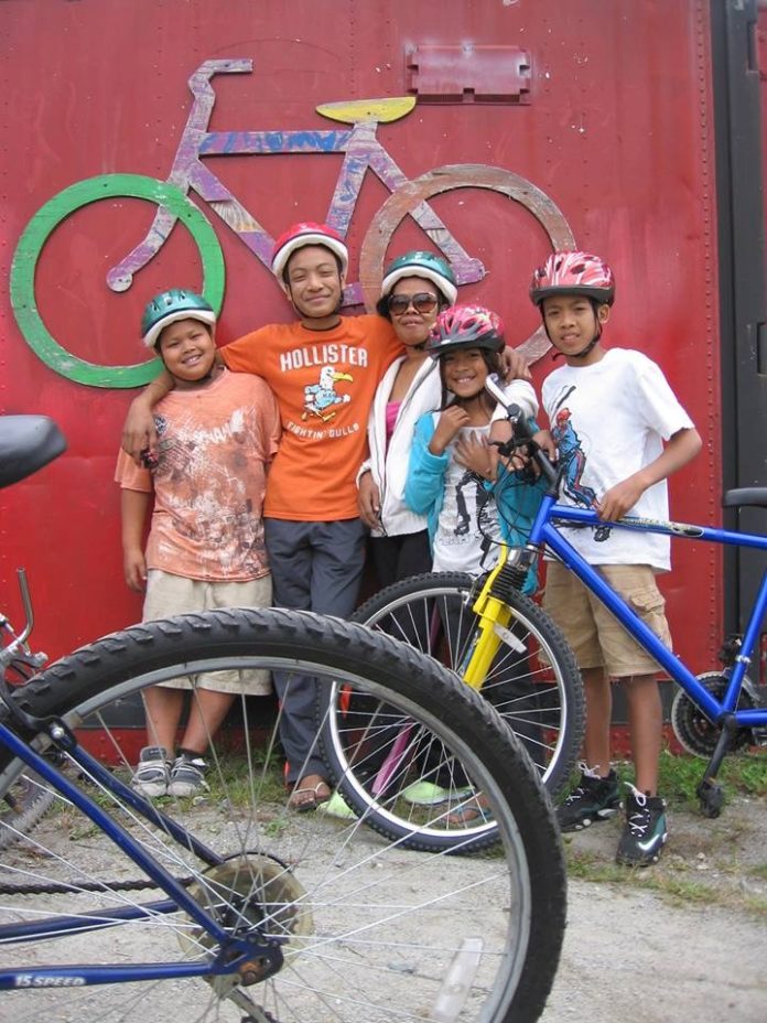 SOME OF the 60 children from around Providence participating in the Red Shed Bike Shop's first Bike Camp stand with their bikes. All participants received their own bicycle, lock, and helmet and learned how to ride, maintain, and stay safe with their bicycle.
