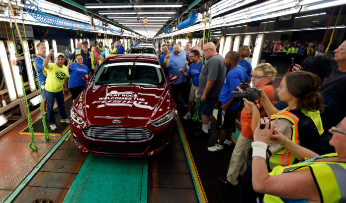 IN A SIGN OF CONTINUING strong spending by American consumers, Ford is increasing the production of its midsize Fusion sedan, adding 1,400 jobs at its Flat Rock, Mich., assembly plant. The first Fusion to come off the line on Thursday is celebrated by workers and company executives. / BLOOMBERG NEWS PHOTO/JEFF KOWALSKY