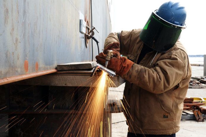 THANKS TO A $100,000 GRANT from the U.S. Commerce Department and matching funds from The Rhode Island Foundation and the R.I. Economic Development Corporation, leaders in the state's academic, governmental and manufacturing sectors are developing a plan to create a manufacturing and design center in the Ocean State. Here a Senesco Marine worker uses a torch to cut steel at the company's North Kingstown facility. / PBN FILE PHOTO/BRIAN McDONALD