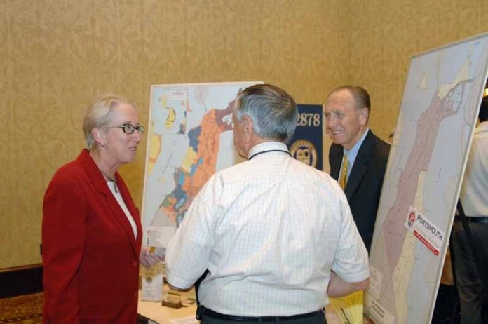 TALKING SHOP: University of Rhode Island’s Business Engagement Center Executive Director Katharine Hazard Flynn, speaks with Portsmouth Business Development’s William E. Clark, yellow tie, and Raymond Sepe, president and CEO of Electro Standards Laboratories, at the “We Mean Business Expo.” / PBN PHOTO/BRIAN MCDONALD