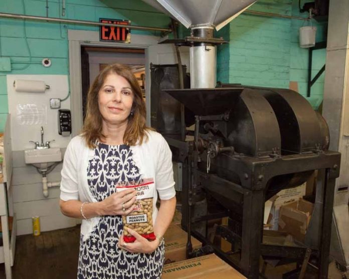NUTS FOR IT: Candace Kaloostian, president of the Virginia & Spanish Peanut Co., represents the third generation to lead the 100-year-old company. On roasting days, the smell of hot nuts has become familiar to anyone in the blocks around the company’s wooden factory on Dexter Street in Providence’s West End. / PBN PHOTO/TRACY JENKINS