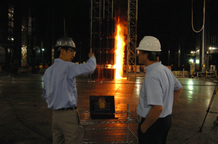 BURN NOTICE: FM Global senior research specialists Yi Wang, left, and Karl Meredith observe a controlled fire at the insurer’s Glocester test facility. / PBN PHOTO/BRIAN MCDONALD