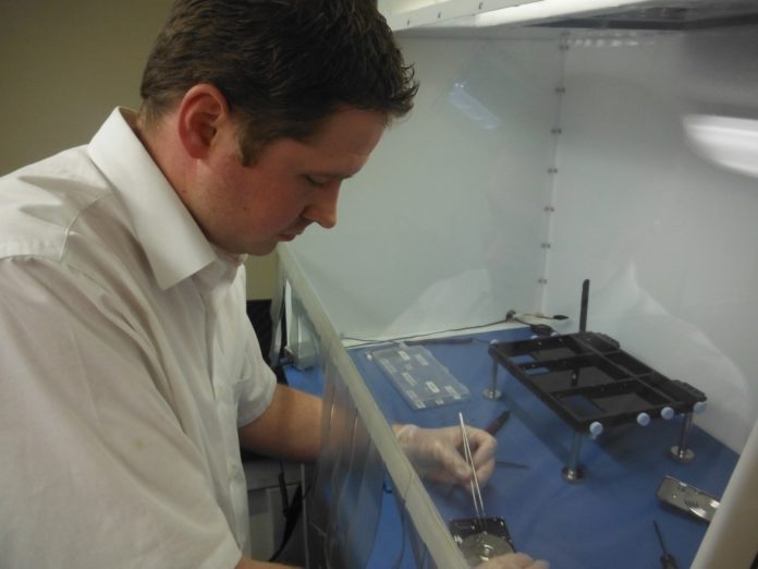 Jared Palmer, founder and owner of Data Medics LLC, works to recover data from a hard drive using a bench-top clean room.