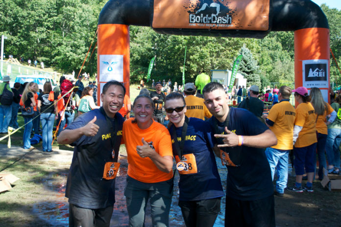 Cranston Mayor Allan Fung, far left, and the Fungamaniacs celebrate after crossing the finish line at the third annual BoldrDash Mud Race. Held Sept. 14-15 at Exeter’s Yawgoo Valley Ski & Water Park, the event attracted more than 2,000 adults and children who worked their way through obstacle courses. Pictured with Fung, from left, are Lynn Hall, president of BoldrDash Race LLC, and Fung’s teammates, Barbara Ann Fenton and Danny Hall. / COURTESY GEORGE ROSS PHOTOGRAPHY