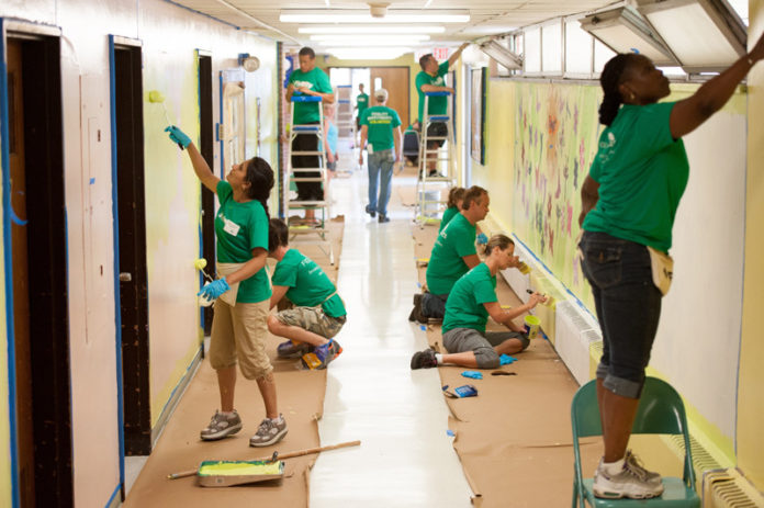 INVESTING TIME: Fidelity Investments volunteers repaint the main hallway at Cunningham Elementary School in Pawtucket on Aug. 16, Fidelity’s Transformation Day. The company has made a decision to invest its corporate goodwill in a focused way, by improving middle school public education. / COURTESY FIDELITY