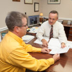 GOING MOBILE: Hunter Insurance President Brian Hunter, white shirt, speaks with customer and CertaPro Painters owner Mark Bulpitt. Hunter is hoping that Rhode Island allows policyholders to access auto-insurance information through mobile devices. / PBN PHOTO/TRACY JENKINS