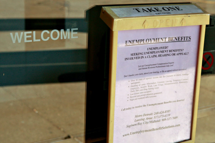 FORMS FOR UNEMPLOYMENT benefits sit outside Michigan's Unemployment Insurance Agency Problem Resolution Offices. Last week, 308,000 Americans filed applications for unemployment benefits, fewer than the 315,000 new jobless claims economists forecast. / BLOOMBERG FILE PHOTO/JEFF KOWALSKY