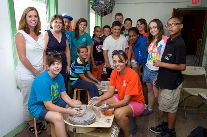 BANKNEWPORT VICE PRESIDENT and Newport Branch Manager Jennifer Pratt, rear left, recently joined students participating in a pottery class at Camp Grosvenor, along with Boys & Girls Clubs of Newport County Executive Director Joanne Hoops second from left, Director of Operations Jaclyn Lewandowski, fourth from left in green, Park Holm Unit Director Lauren Day, back row in orange, and camp counselor Keila Sanchez, seated front.