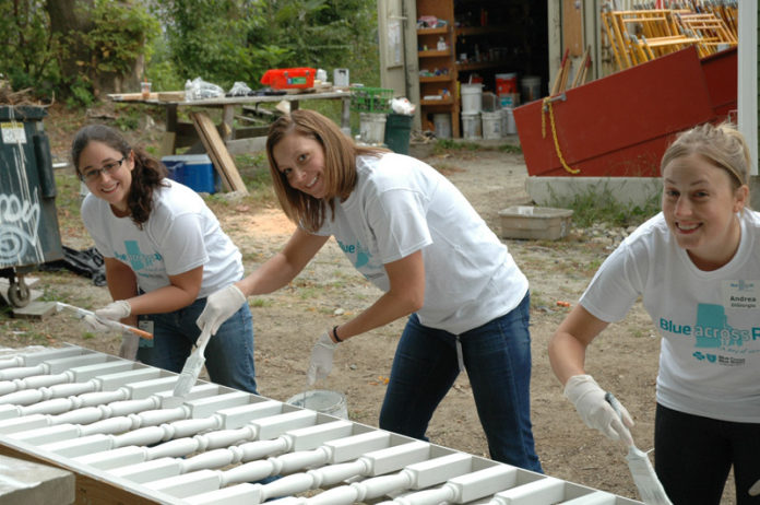 BLUE CROSS & BLUE SHIELD OF RHODE ISLAND employees help build homes for Habitat for Humanity in Providence during the company’s statewide day of community service. From left: Sarah Renaud, budgets team leader; Kristen Burgoyne, cost-accounting team leader;  and Andrea DiGiorgio, accounting specialist.