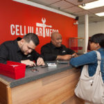 GOOD RECEPTION: Cellular Medic was born in 2009 in Massachusetts, expanding to a second shop on Atwells Avenue in Providence in March. Pictured above are co-owners Eli Acevedo, left, and Derek Coelho with customer Raylah Philip. / PBN FILE PHOTO/TRACY JENKINS
