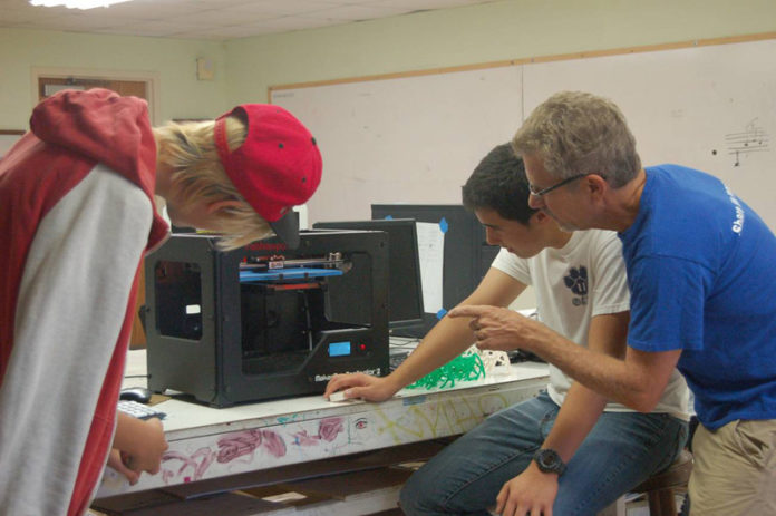 ABSOLUTLEY FABULOUS: Students Kaysa Shea and Kyler Dillon and East Bay Met School teacher Steve Heath work on a 3-D printing project as part of FabNewport’s efforts to promote technical knowledge and passion. / COURTESY CAMERON BLAISDELL