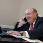 GOING BACK: Joe Botelho made unsuccessful attempts to finish college in the 1980s and &rsquo;90s. A return-to-college program has the associate at Re/Max River&rsquo;s Edge in East Providence poised to graduate from RIC in December. / PBN PHOTO/BRIAN MCDONALD