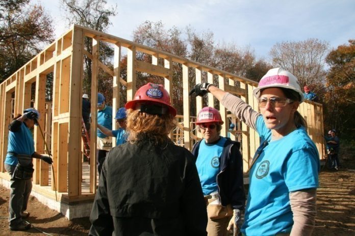 NAILING IT: Laura Reed, forewoman for the all-women construction crew building a house for Habitat for Humanity in South Kingstown, gestures while talking to crew members Carol O’Donnell, foreground left, and Christine Fitzpatrick, center. / PBN PHOTO/MICHAEL PERSSON