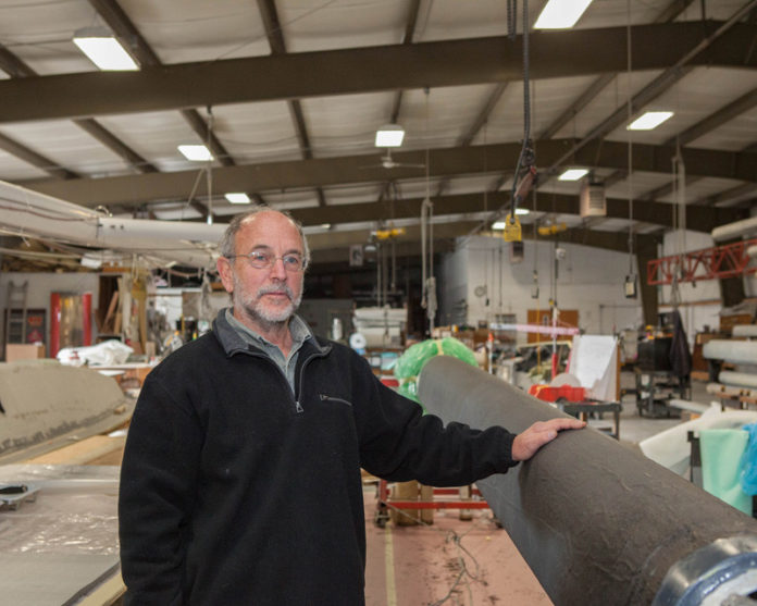 COMPOSITE SKETCH: David Schwartz, president of GMT Composites Inc., shows off one of his company’s sailboat booms. GMT was founded in 1984 by a group of fiberglass and composites experts. / PBN FILE PHOTO/TRACY JENKINS