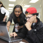 TECH SUPPORT: Science teacher Malika Al works with student Joshua Estrada at the Sheila C. &ldquo;Skip&rdquo; Nowell Leadership Academy, which opened its doors on Sept. 16. / PBN PHOTO/MARTIN GAVIN