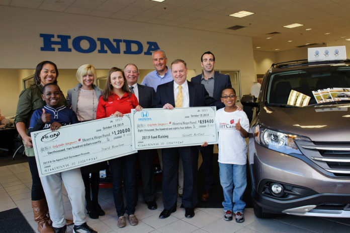 HEART & HOPE EXECUTIVE DIRECTOR LOUISE DINSMORE (second from left, back) accepted donations from Hi-On Apparel and Herb Chambers Honda of Seekonk alongside Lauren Landry and Joshua Jean Louis, participants of the fund’s programs. From left: Joshua’s mother and brother, Edith and Isaiah Jean Louis; Dinsmore; Heart & Hope Fund board member Ron Cascione; Lauren’s father, Dan Landry; Herb Chambers Honda of Seekonk General Manager Scott Birtles; Hi-On Apparel’s David Beuhne and Louis.