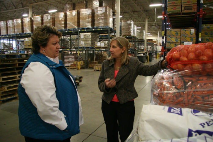 SATISFYING A NEED: Because summer slows down donations to the Rhode Island Community Food Bank, Citizens Bank created a partnership with the Pawtucket Red Sox and Cox Communications that has yielded $500,000 for the food bank in the last six years. Above, Kathy O’Donnell, senior vice president at the bank, left, talks with Lisa Roth Blackman, chief philanthropy officer at the food bank. / PBN PHOTO/MICHAEL PERSSON