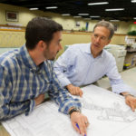 REBUILT FOR SUCCESS: With a commitment to its customers reflected in new products and the adoption of lean principles, DiPrete Engineering has thrived since the Great Recession. Above, Eric Prive, left, works with company CEO Dennis DiPrete. / PBN PHOTOS/DAVID LEVESQUE