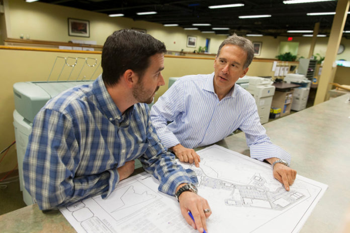 REBUILT FOR SUCCESS: With a commitment to its customers reflected in new products and the adoption of lean principles, DiPrete Engineering has thrived since the Great Recession. Above, Eric Prive, left, works with company CEO Dennis DiPrete. / PBN PHOTOS/DAVID LEVESQUE