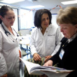 A CARING SPIRIT: Thanks to volunteers like student nurse Marissa Roberge, left, and nurse practitioner Rebedda Carley, right, Rhode Island Free Clinic CEO Marie Ghazal has been able to expand the number of clinic visits 400 percent since 2008. / PBN PHOTO/STEPHANIE ALVAREZ EWENS