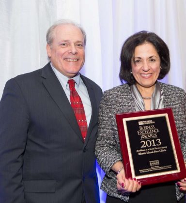 Marie Ghazel, CEO of Rhode Island Free Clinic accepts her award from Mark Murphy / Rupert Whiteley