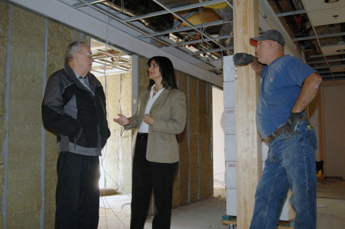 BUILDING SOMETHING: Baltic Group Managing Partner Irene Schmitt surveys 400 Wesminster St. with Harold Antonson, grey jacket, city of Providence electrical inspector, and Don Hardy of Sheridan Electric. / PBN PHOTO/BRIAN MCDONALD