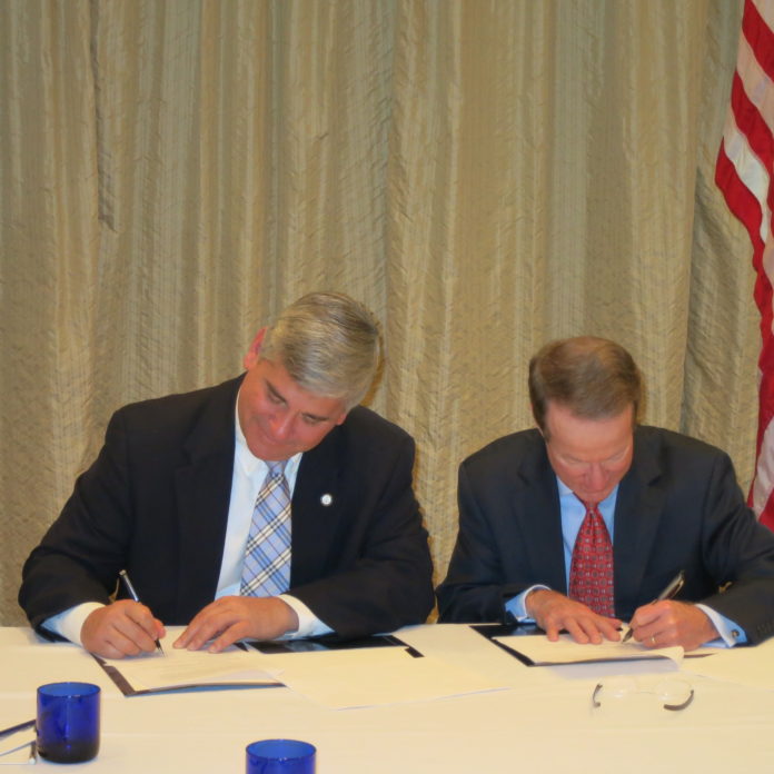 ATTORNEY GENERAL Peter F. Kilmartin (left) and Ambassador William R. Brownfield (right), assistant secretary of state for international narcotics and law enforcement affairs, signed a partnership agreement Tuesday in which Rhode Island will provide prosecutorial training to the U.S. State Department's foreign partners. / COURTESY R.I. ATTORNEY GENERAL'S OFFICE