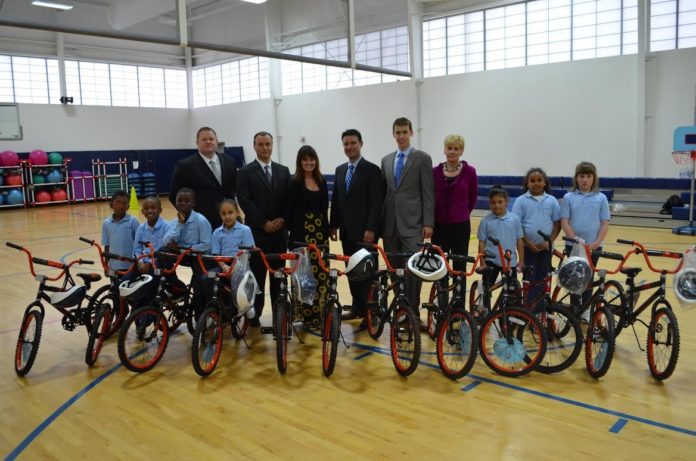 FROM LEFT: Joseph Kotula, Ed Pelletier, Erin Foley, Nicholas DiLello, Jr., Andrew Pelletier, and Donna Ricci from Barnum Financial Group, an office of MetLife, stand with students from The Grace School at Meeting Street. Students recently received donated bicycles from the friends of Foundation for Life Inc.