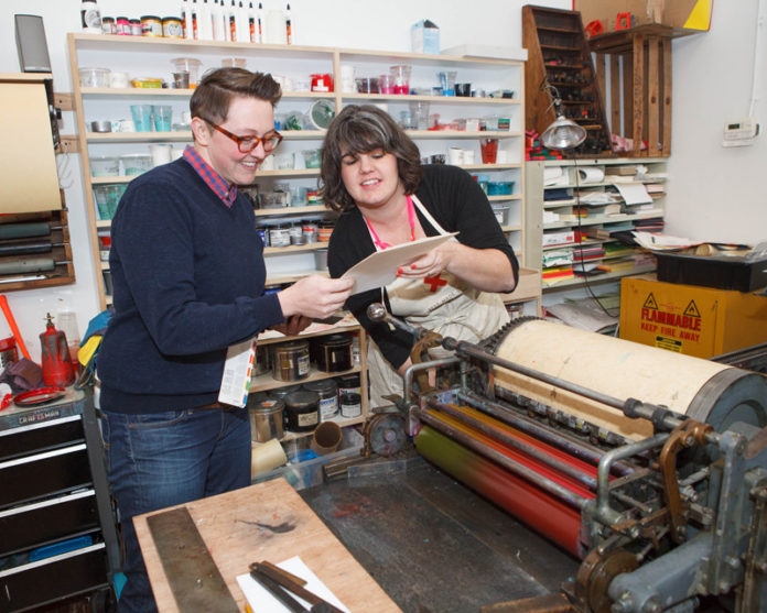 WORDS’ WORTH: Arley-Rose Torsone and Morgan Calderini, co-owners of Ladyfingers Letterpress, founded the Pawtucket company in 2011. The company makes custom-designed invitations and greeting cards that personalize the message with old-fashioned hand lettering. / PBN PHOTO/TRACY JENKINS