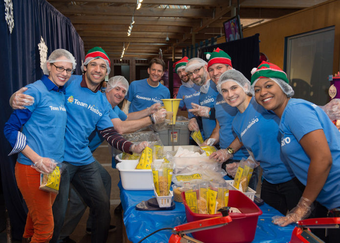 Team Hasbro employees join Hasbro Inc. President and CEO Brian Goldner, rear middle, on Dec. 6, assembling and packaging more than 136,000 meals for families in need at the company’s Pawtucket headquarters. The work was part of the company’s first Global Day of Joy, a service-oriented initiative involved Hasbro’s 5,000 employees worldwide. The Pawtucket effort was in partnership with Outreach Inc. – a U.S.-based hunger-relief organization. / COURTESY CONSTANCE BROWN