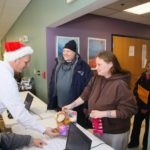MAYOR DONALD R. GREBIEN helps Pawtucket couple Paul and Liza Nighan pick up toys and warm clothing items for their 5-year-old daughter. / COURTESY CITY OF PAWTUCKET